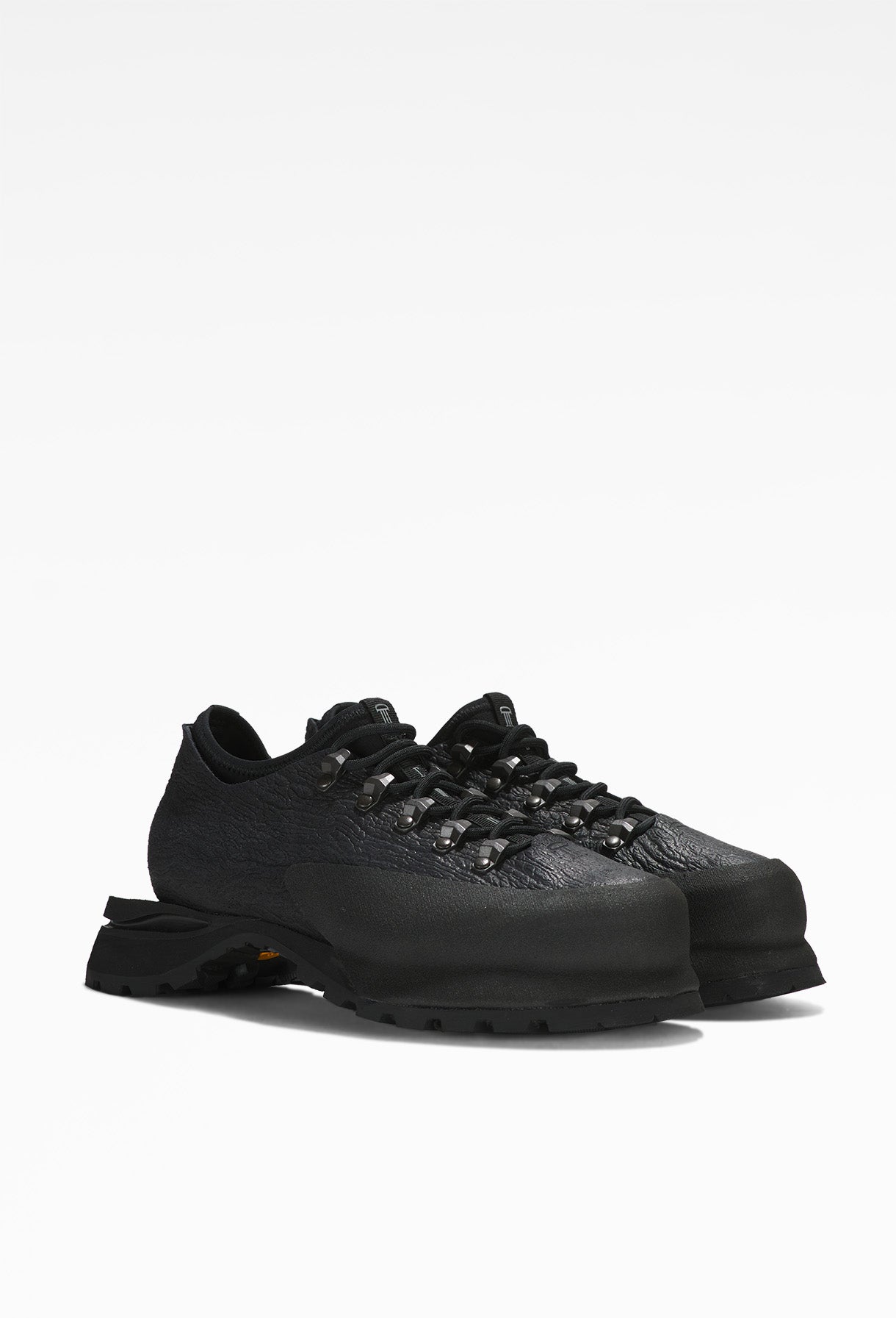 Sleek black hiking shoe with low-cut design, black laces, textured fabric upper, and rugged, thick rubber sole.